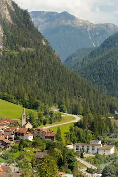 A serene view of a traditional Swiss village nestled in the lush Alps, ideal for peaceful retreats.