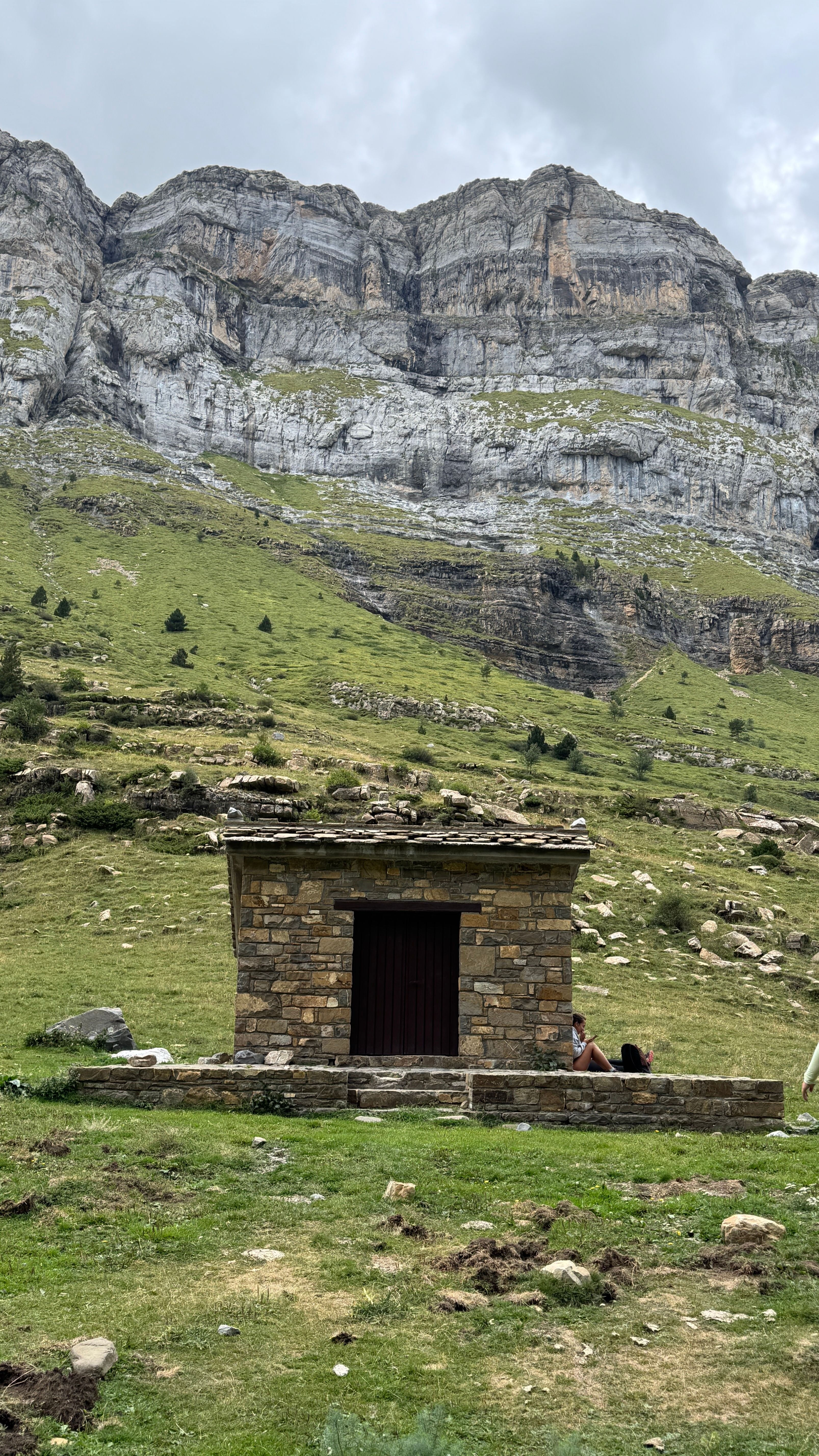 Scenic view of a rustic stone hut set against the picturesque mountains of Torla-Ordesa in Aragon, Spain.