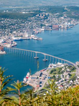 A breathtaking aerial view of Tromsø, featuring the iconic bridge and picturesque fjord landscape.