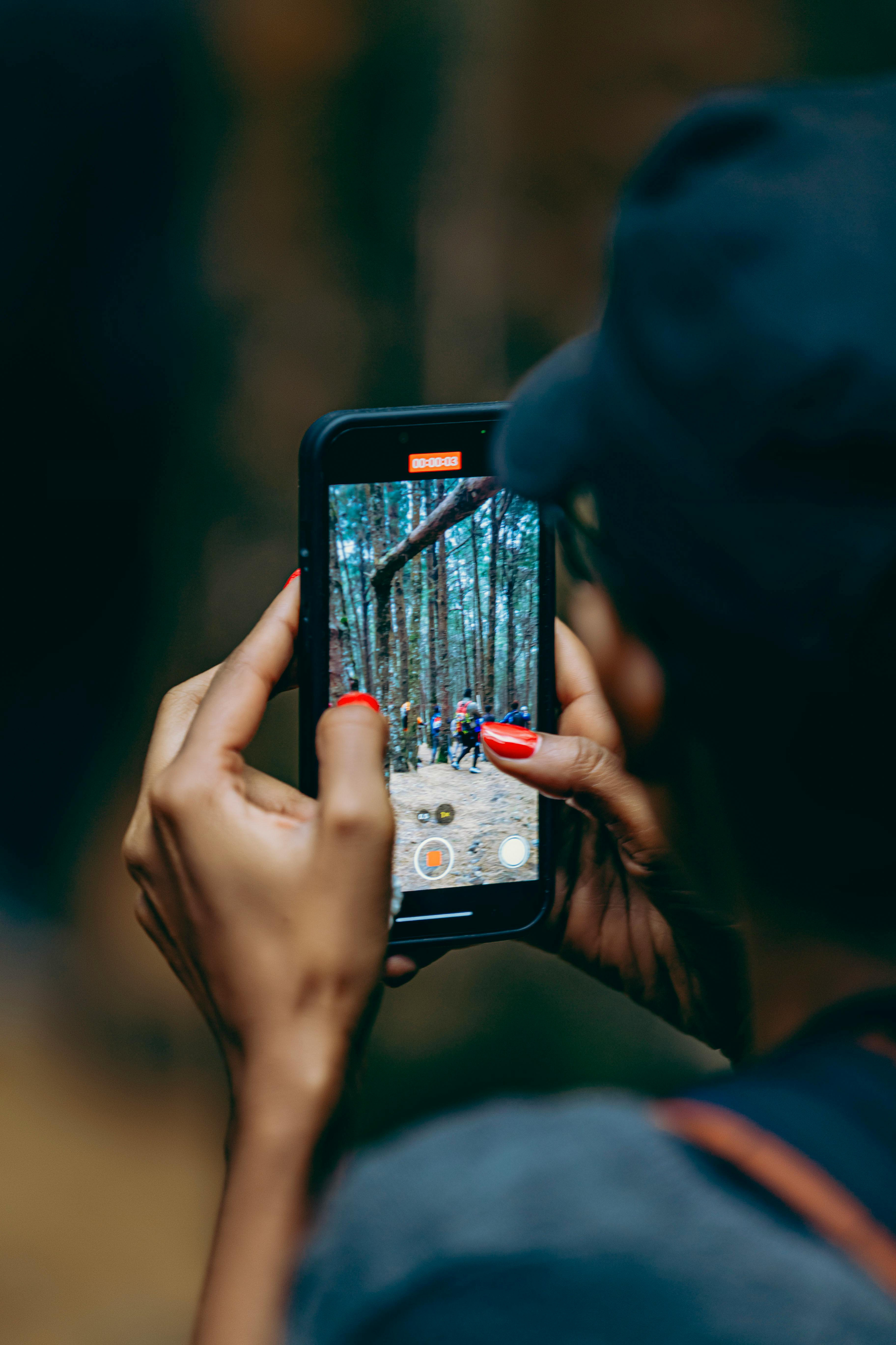 Zadarmo Osoba zachytáva lesnú scenériu smartfónom počas túry. Fotka z fotobanky