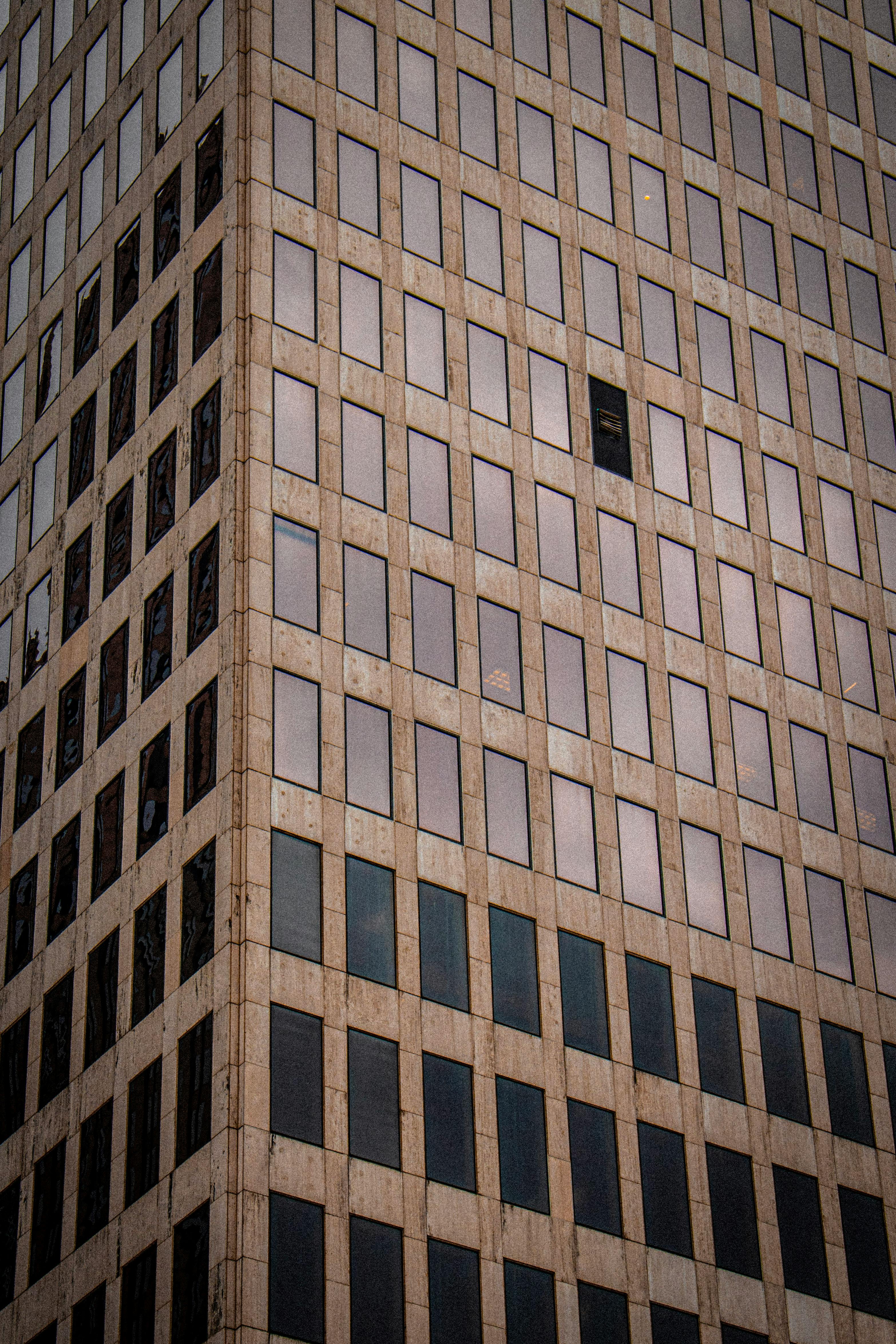 Gratuit Vue rapprochée de la façade d'un gratte-ciel moderne à Houston, présentant une architecture géométrique et des fenêtres réfléchissantes. Photos