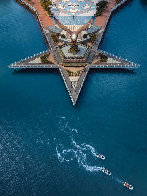 Free A stunning aerial shot of the iconic Eagle Square in Langkawi, Malaysia, featuring boats on blue waters. Stock Photo