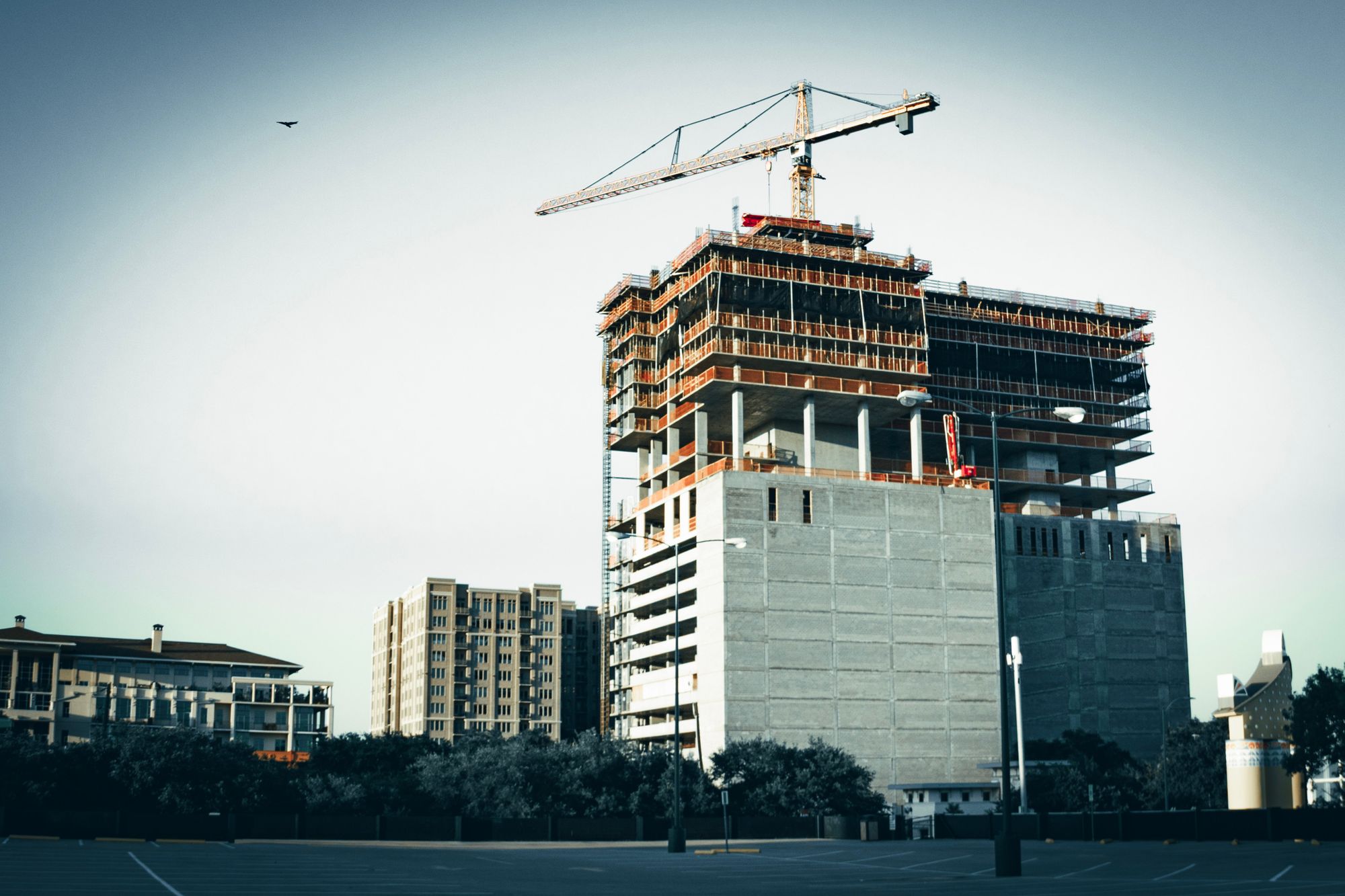 Estructura metálica de una nave industrial en construcción, con andamios y maquinaria al fondo