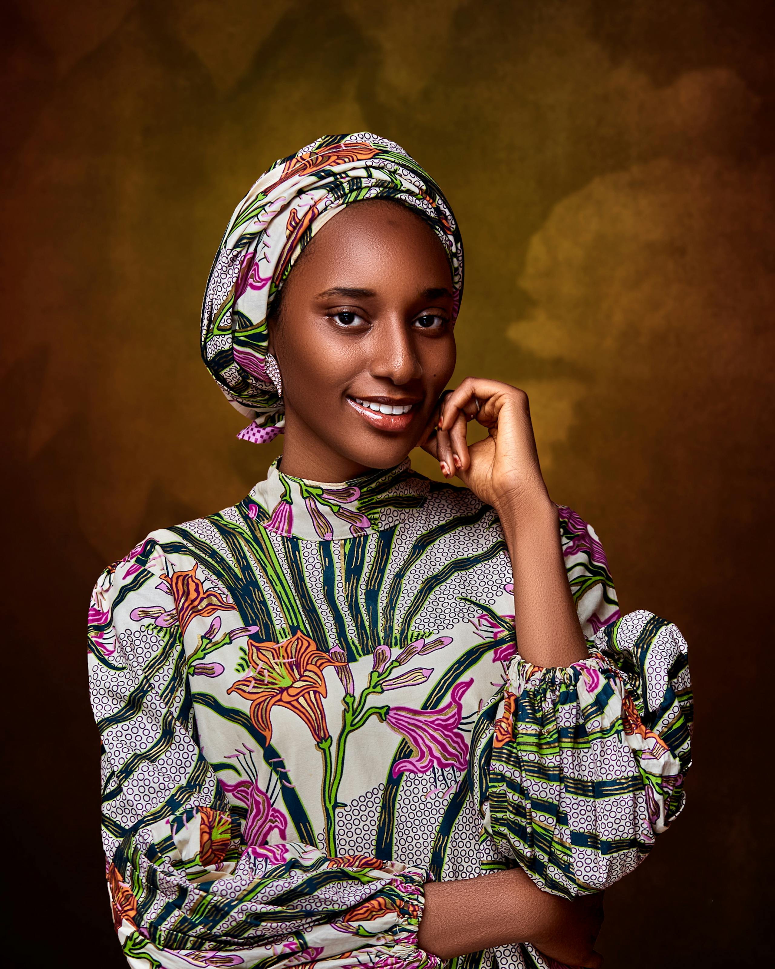 Free Beautiful portrait of a smiling Nigerian woman in traditional attire against a textured background. Stock Photo