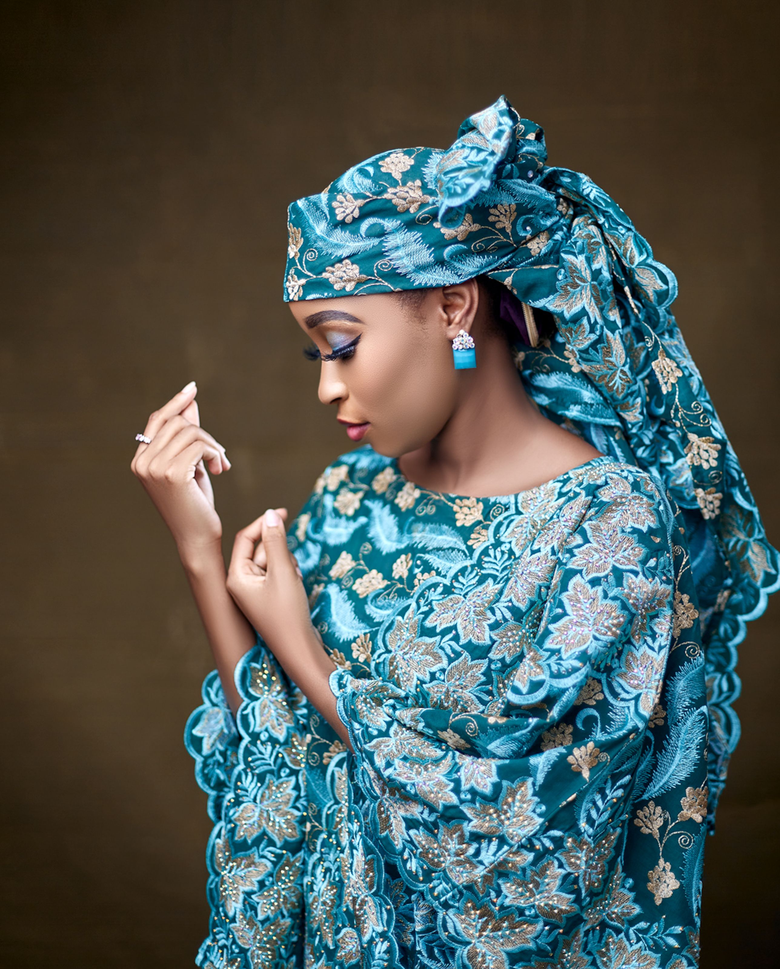 Side profile portrait of a Nigerian woman in blue traditional attire, showcasing elegance and cultural fashion.