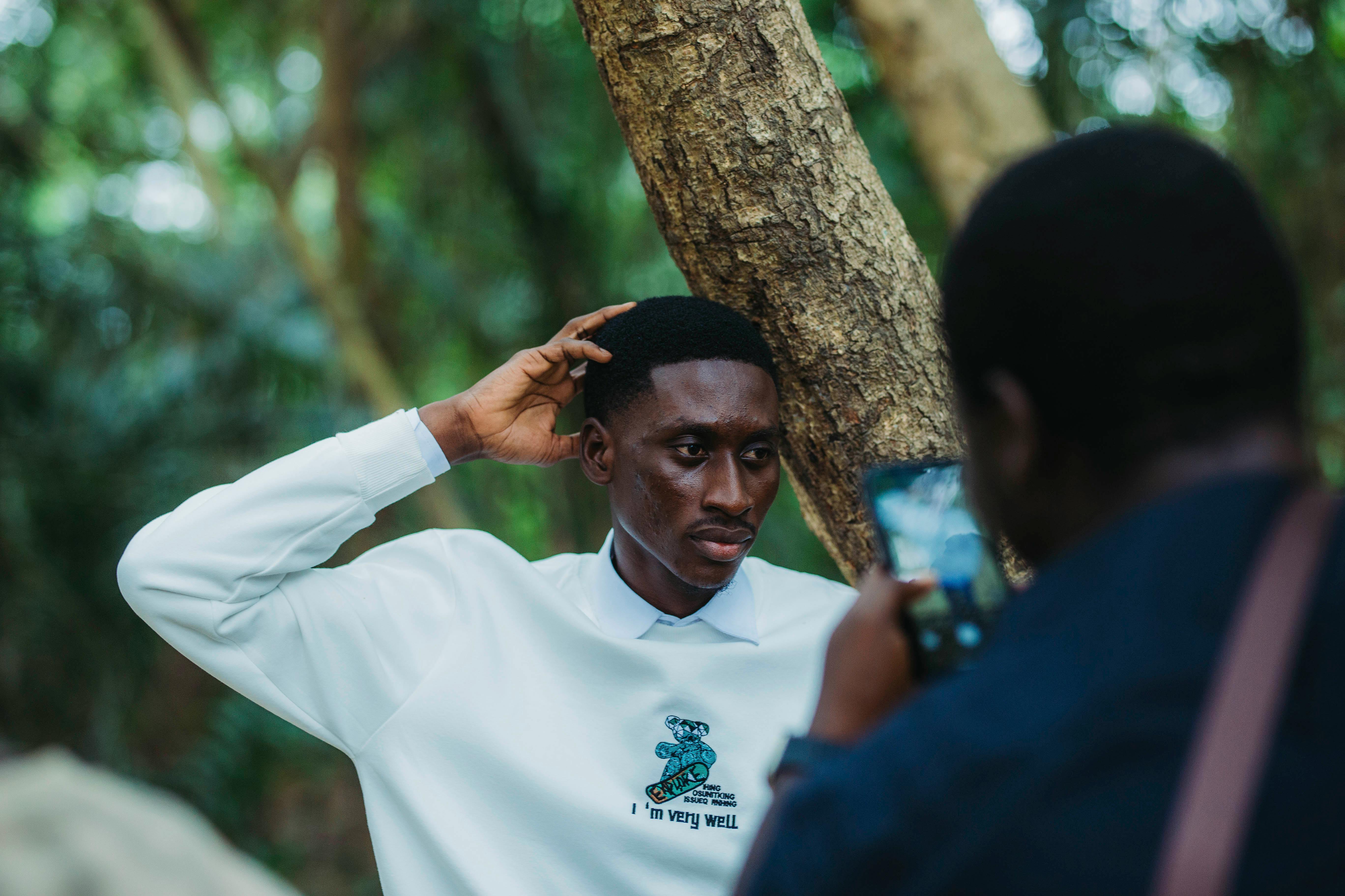 Man posing candidly in an outdoor portrait shoot in Accra's lush forest setting.