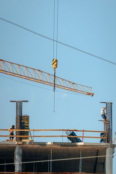 High-rise construction site with workers and crane under clear sky in Bratislava.