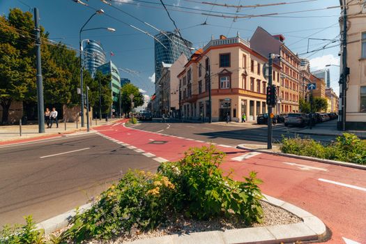 Sunlit street in Bratislava with modern and historic architecture.