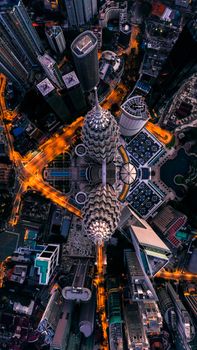 Stunning aerial view of the iconic Petronas Towers in Kuala Lumpur, Malaysia, at night.