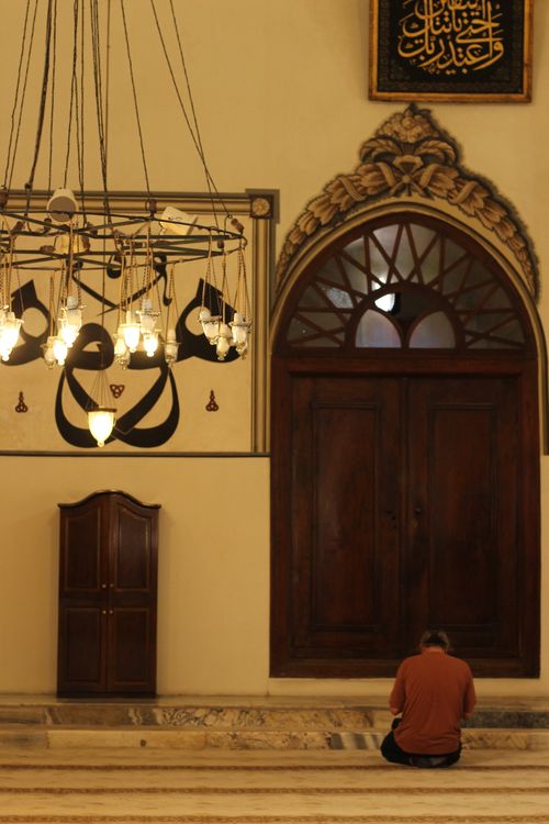 Free A serene moment of contemplation inside a historic mosque with traditional decorations. Stock Photo