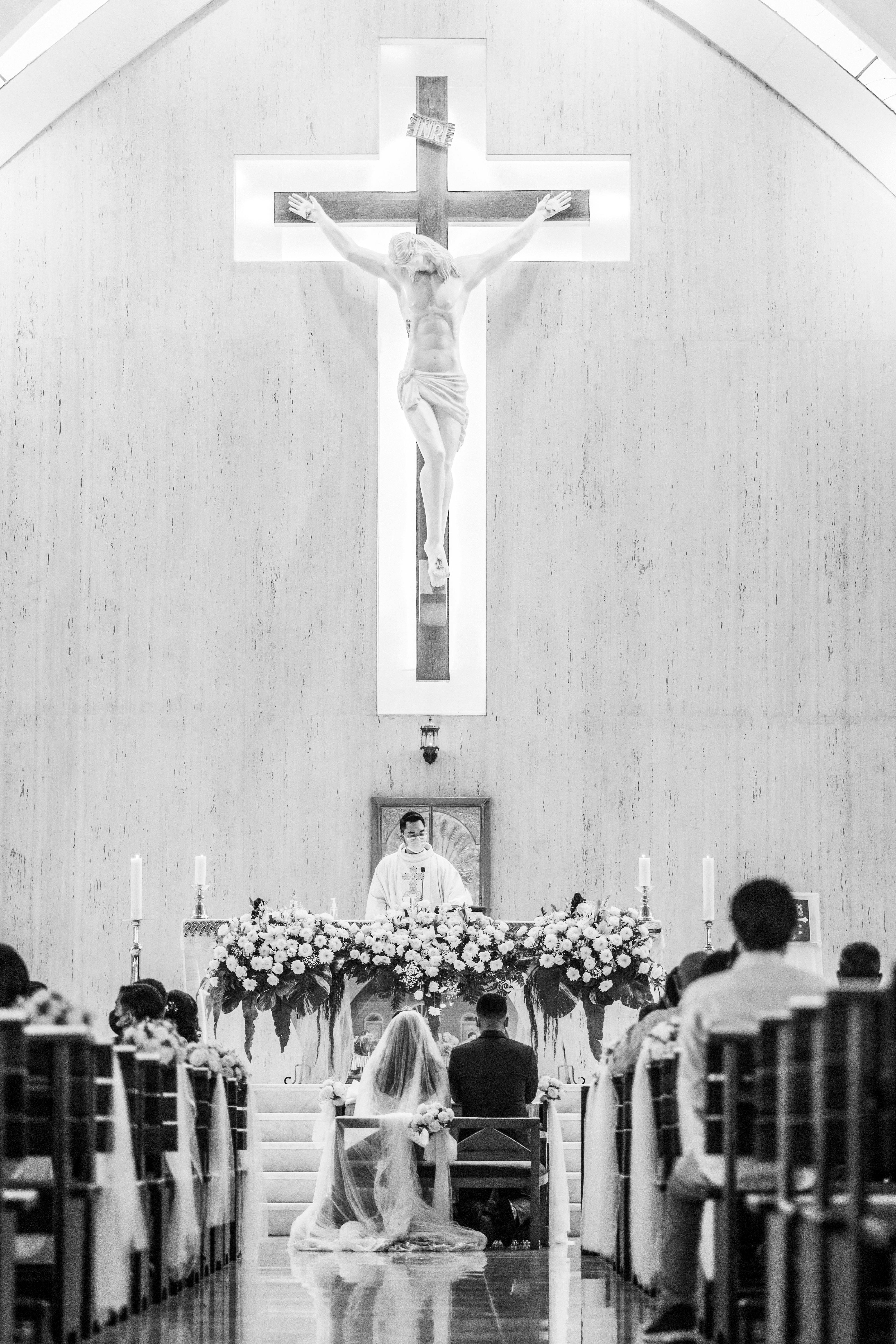A heartfelt wedding ceremony in a church with a couple kneeling before the altar.
