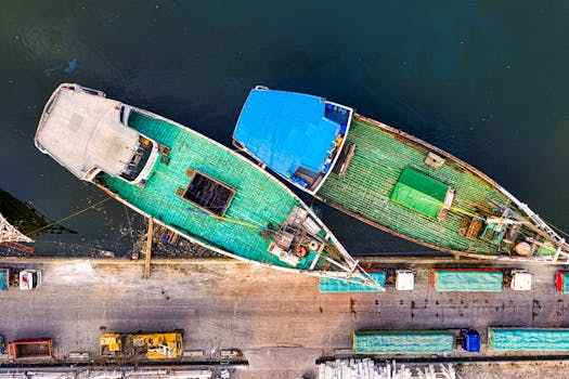 Top-down drone shot of docked cargo boats at a bustling marina with vibrant covers.