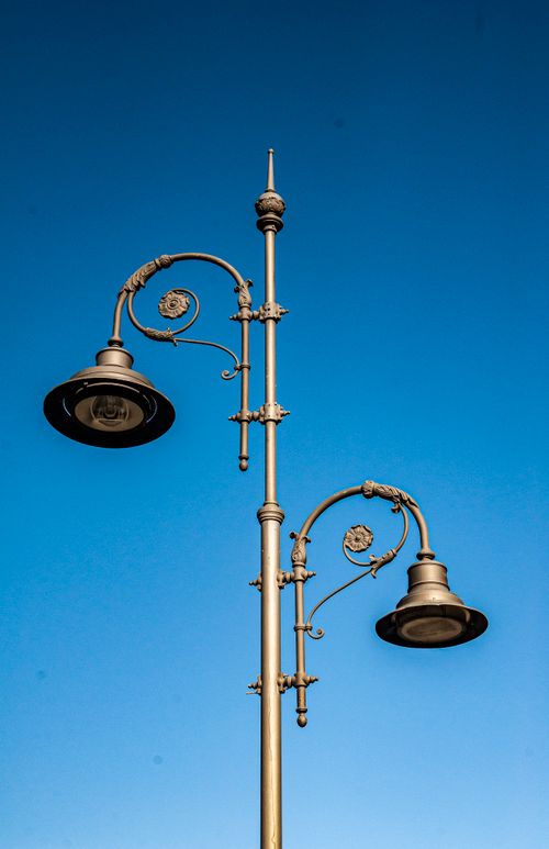 Free Vintage-style street lamps captured against a vivid blue sky, showcasing classic urban design in Tbilisi, Georgia. Stock Photo