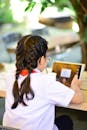 Young Girl Studying with Tablet Outdoors