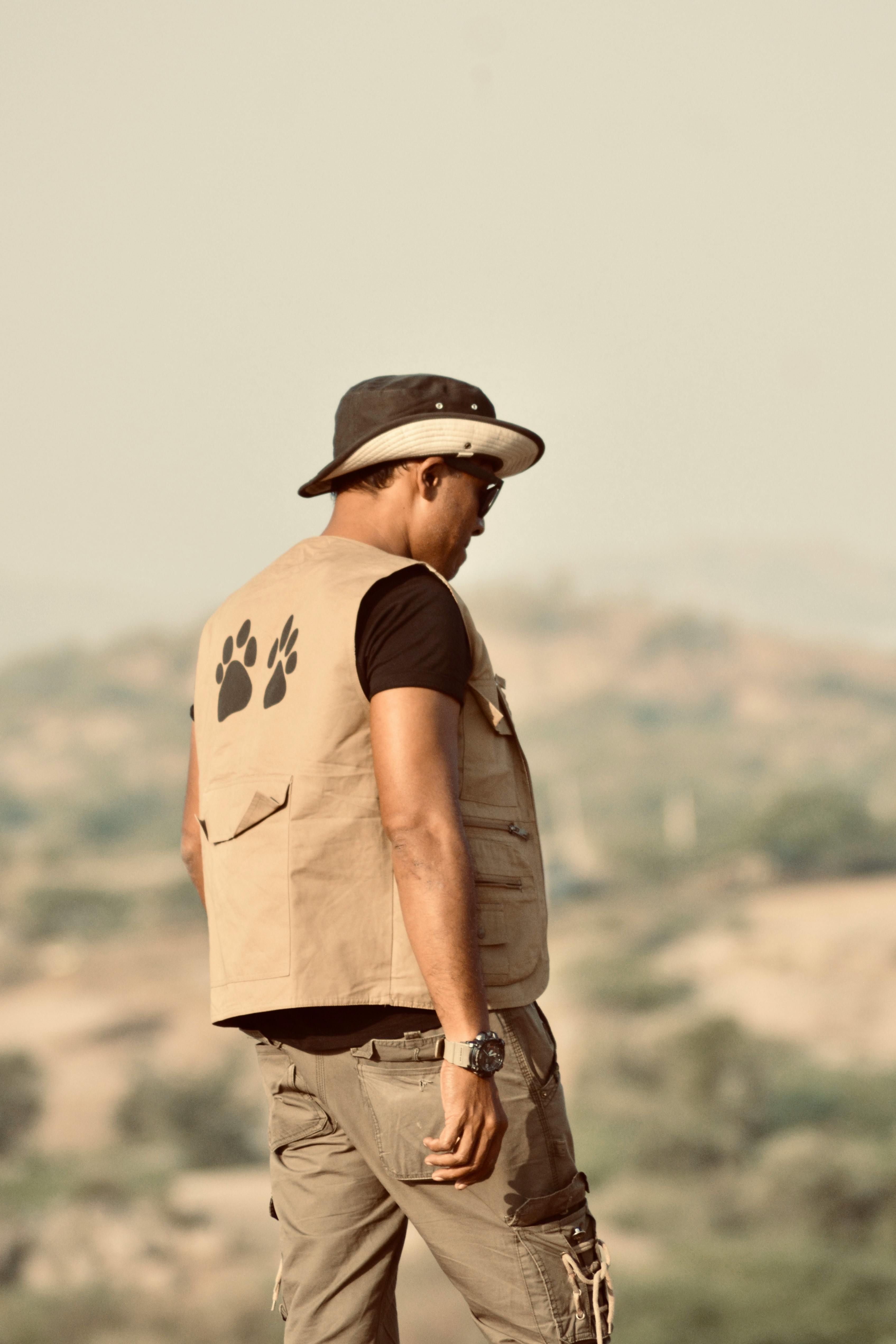 A man in safari gear looking over a scenic landscape, perfect for adventure themes.