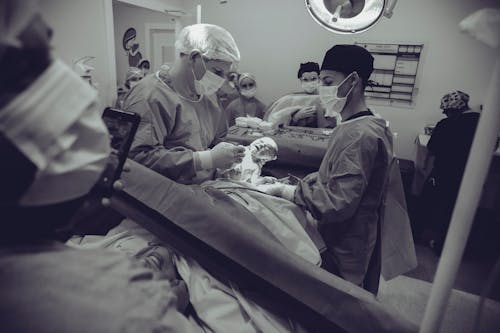 Grayscale Photography of Doctor Holding Baby