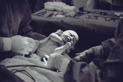 Grayscale Photography of Unknown Person Carrying Newborn Baby