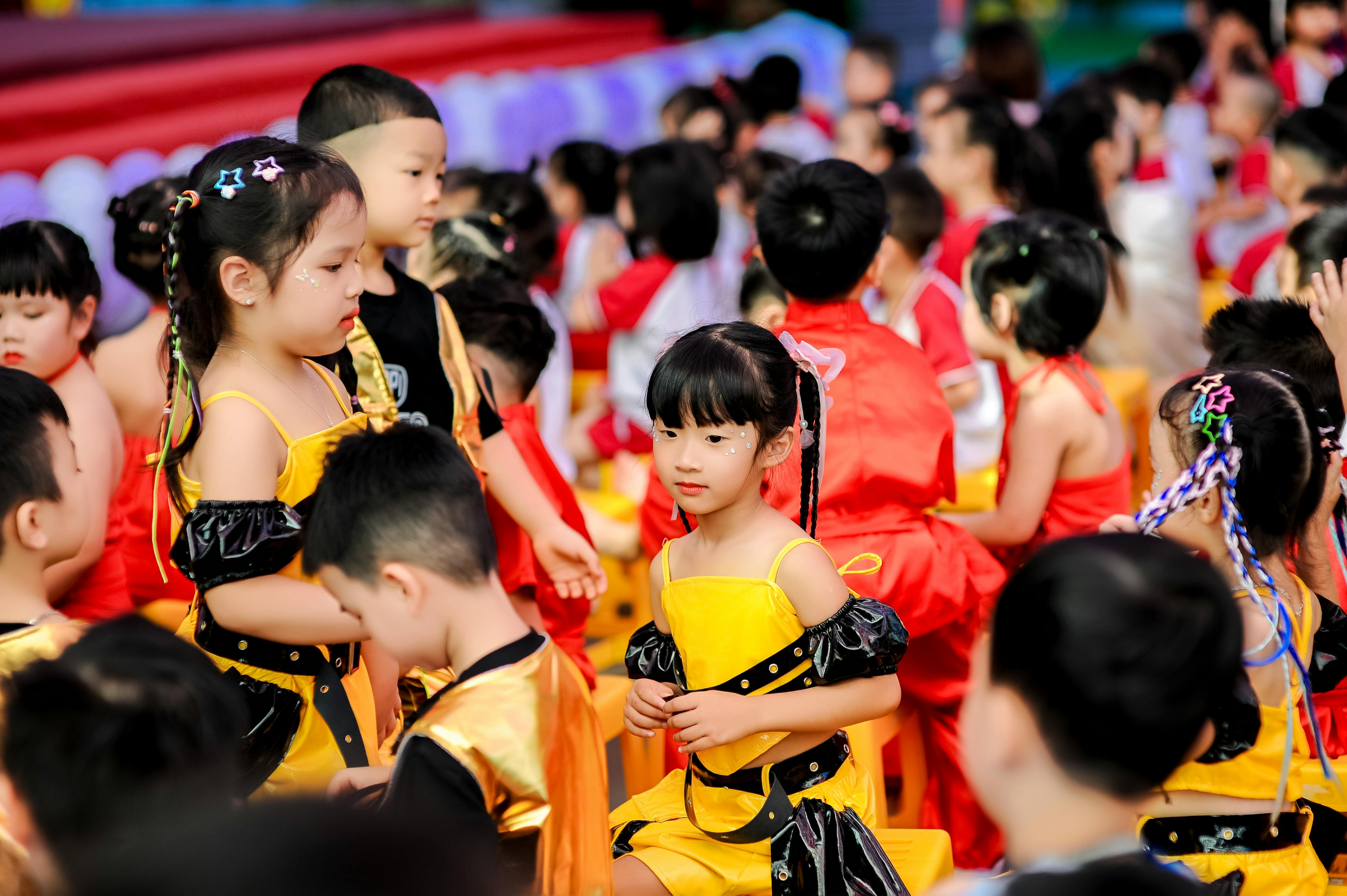 Group of children attending a colorful event in Hà Nội, dressed in vibrant costumes.