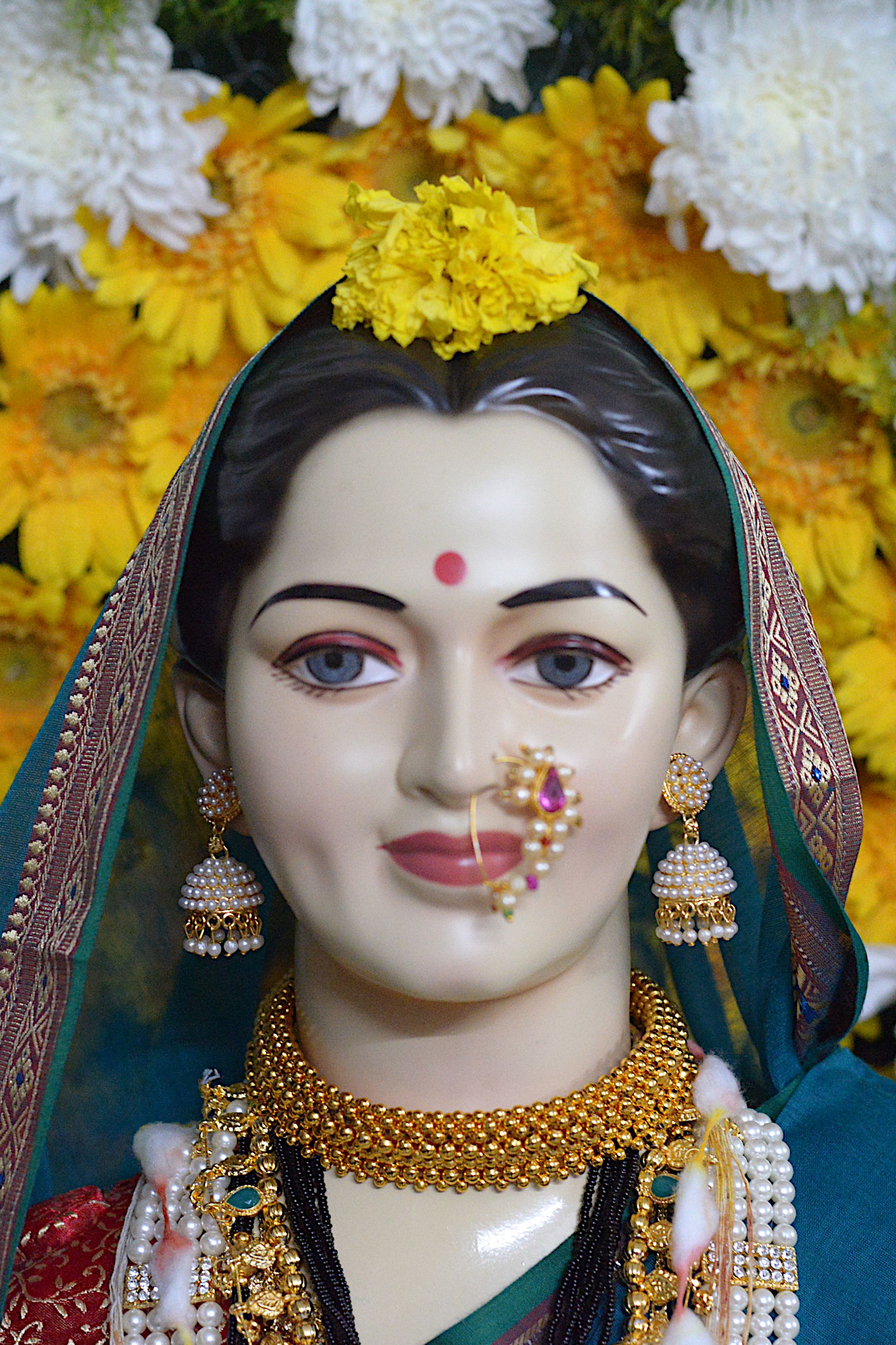 Traditional Gauri idol beautifully decorated with flowers and jewels during Ganesh Chaturthi in Pune, India.