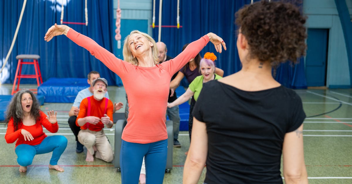 A group of enthusiastic adults participating in a lively circus workshop indoors, showcasing teamwork and joy.