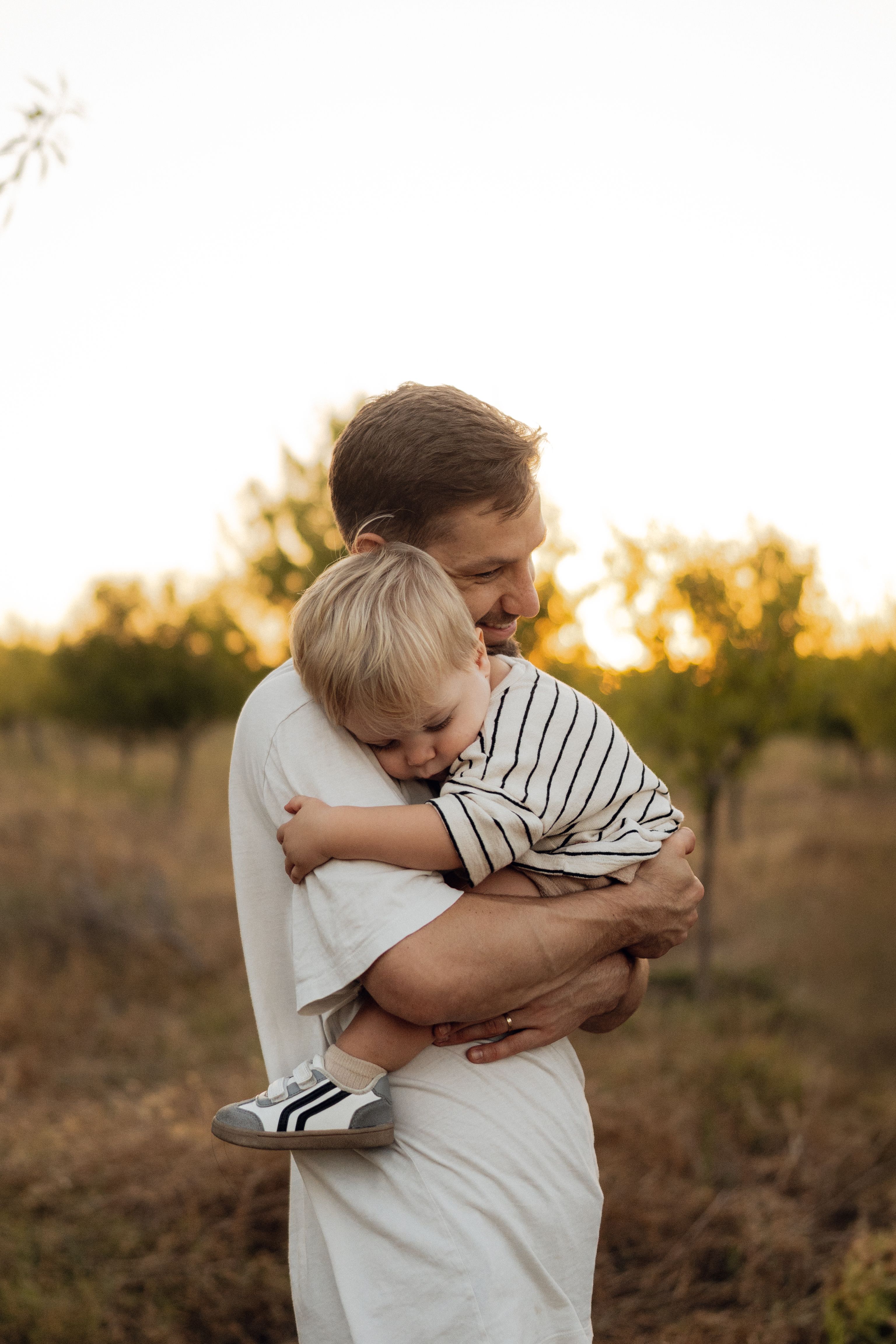 Mamá abraza a su hijo al atardecer