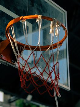 A close-up view of an outdoor basketball hoop and net with blurred background.