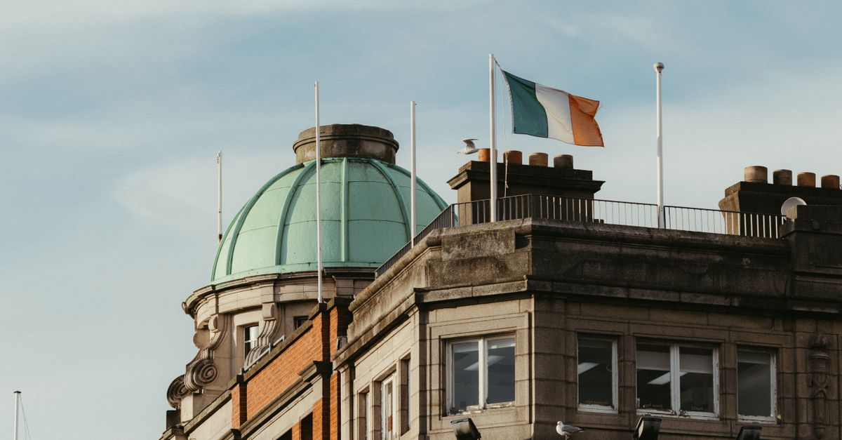 Historic Dublin architecture with the Irish flag waving prominently on a sunny day.