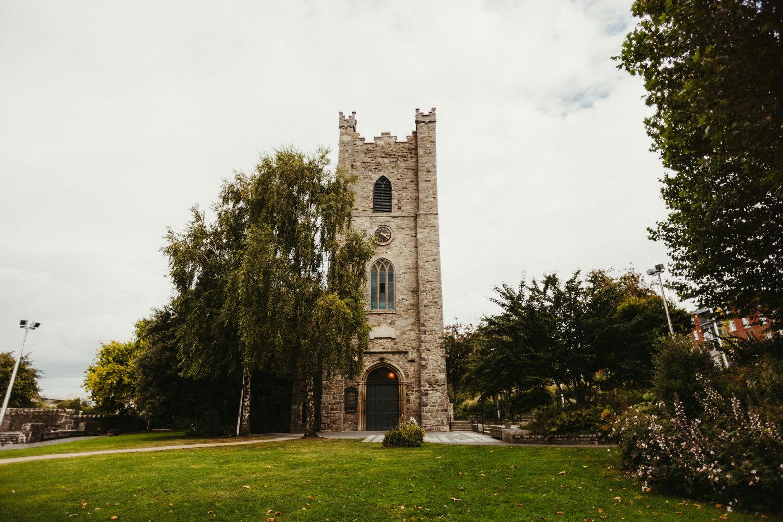 View of the historic St. Audoen's Church surrounded by greenery in Dublin, Ireland