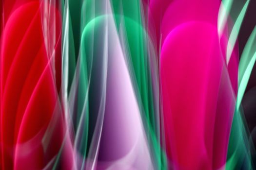 Dynamic abstract artwork featuring vivid light trails in red, pink, green, and purple hues.