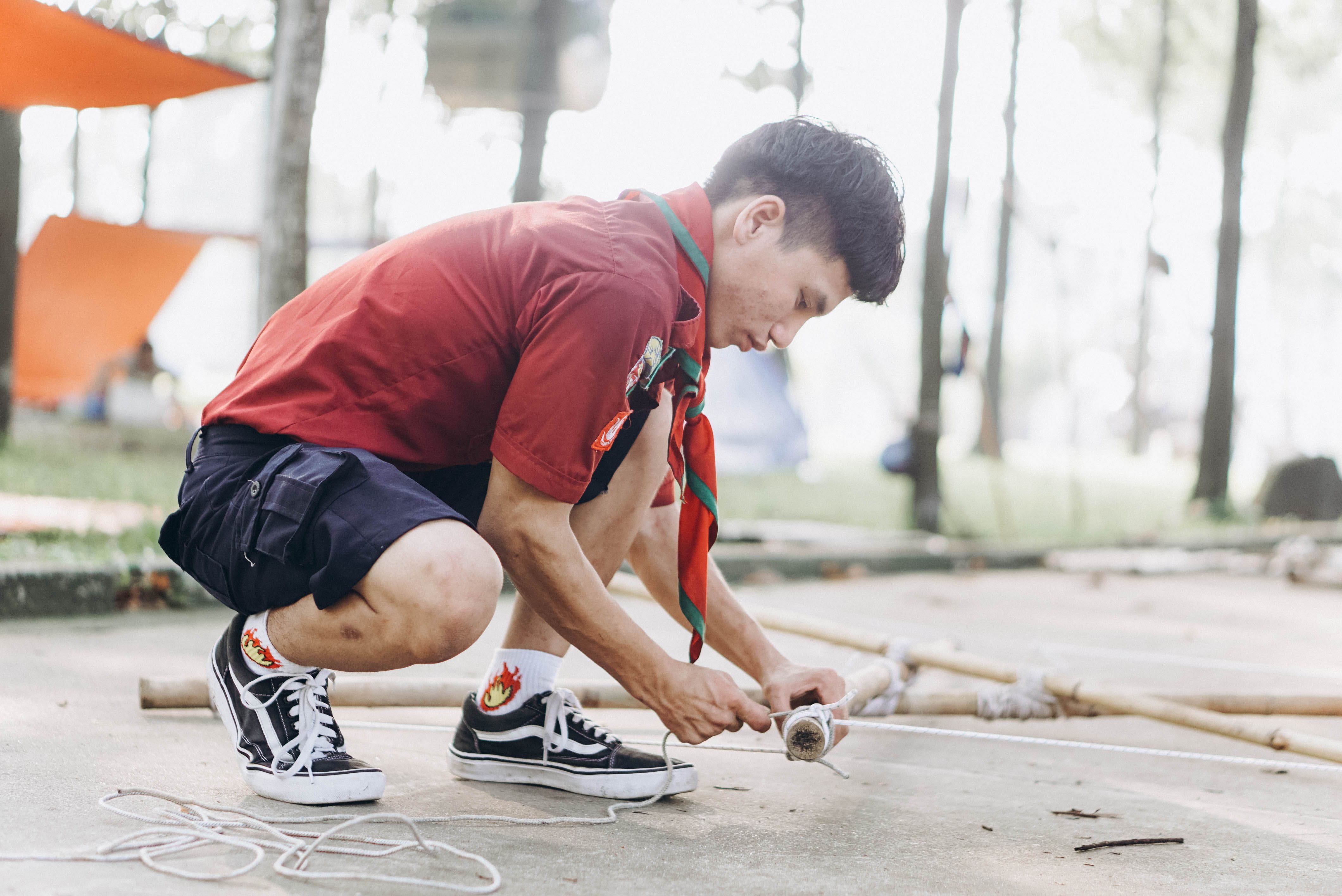 Young Scout Tying Knot In Outdoor Camp Setting Free Stock Photo