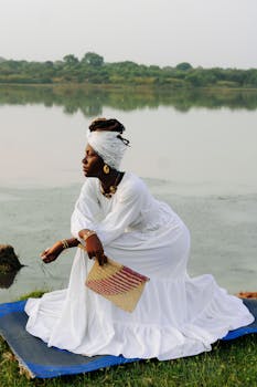 Captivating portrait of a woman in traditional attire by a serene lake in Zaria, Nigeria.