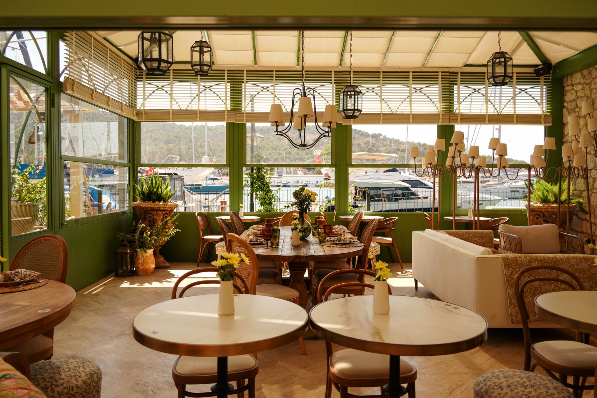 Bright indoor restaurant with elegant decor and marina view. Perfect for dining by the sea.