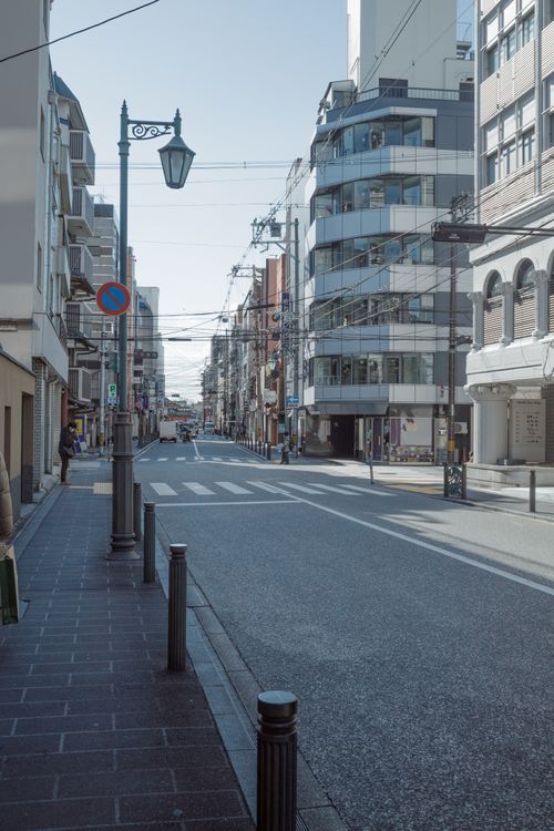 Free A serene view of a modern urban street surrounded by contemporary architecture and clear skies. Stock Photo