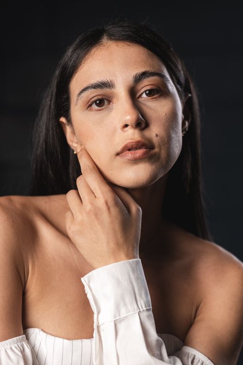 Free Close-up shot of a young woman with a reflective expression and stylish outfit. Stock Photo