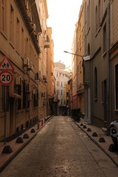 Warm tones of a tranquil narrow street in İstanbul with evening sunlight.