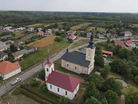 Aerial shot of Aranyosapáti, Hungary, showcasing two prominent churches amidst rural landscape.
