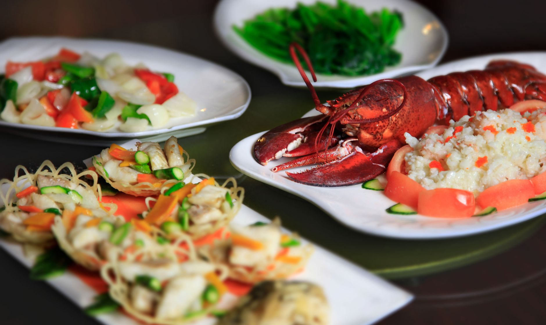 Delicious seafood feast with lobster, veggies, and rice arranged on elegant plates.