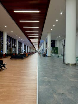 Spacious airport terminal corridor with seating and bright lighting.