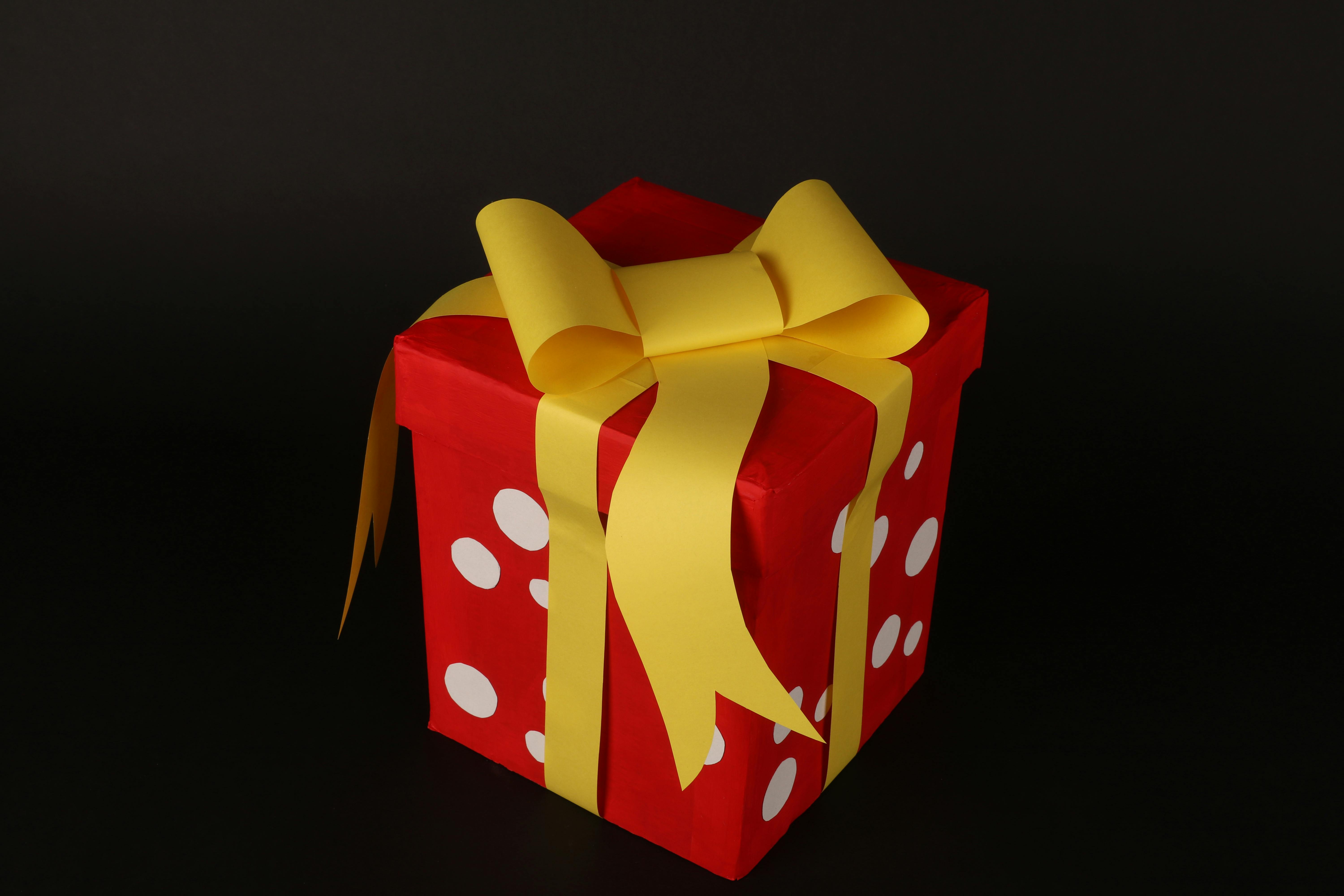 Gratis Llamativa caja de regalo roja con lazo amarillo, perfecta para celebraciones y días festivos. Foto de stock