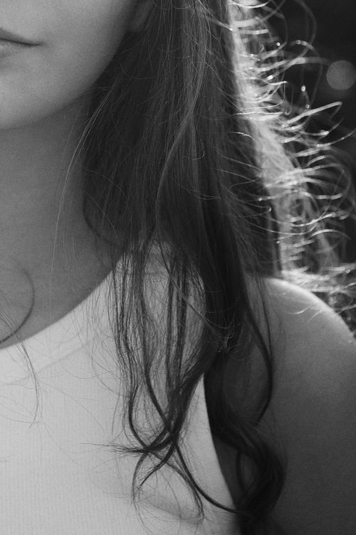 Free Artistic black and white close-up portrait of a young woman with flowing hair. Stock Photo