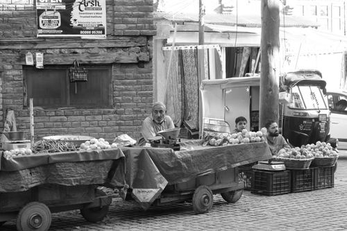 Free Black and white image of street vendors at an outdoor market, selling fresh produce. Stock Photo