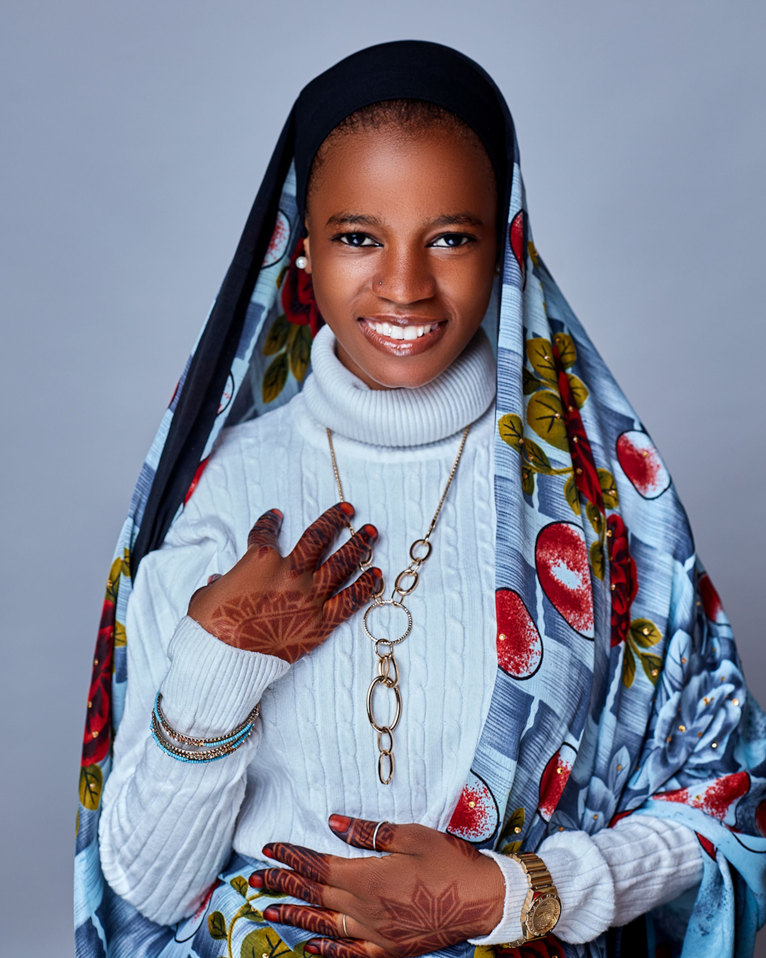 Stunning portrait of a Nigerian woman with a vibrant scarf, henna design, and elegant jewelry.