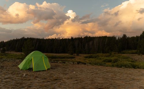 Free Explore the serene beauty of Wyoming's Wind River Range with a lone green tent under dramatic clouds. Stock Photo
