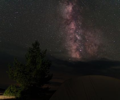 Camping under the stunning Milky Way in Wyoming's wilderness. Perfect for adventure seekers.
