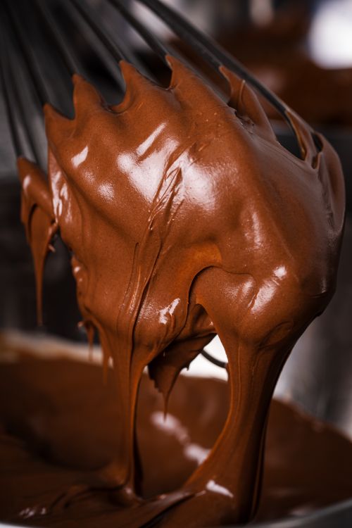 Free Rich, creamy chocolate batter dripping off a whisk, perfect for dessert recipes. Stock Photo