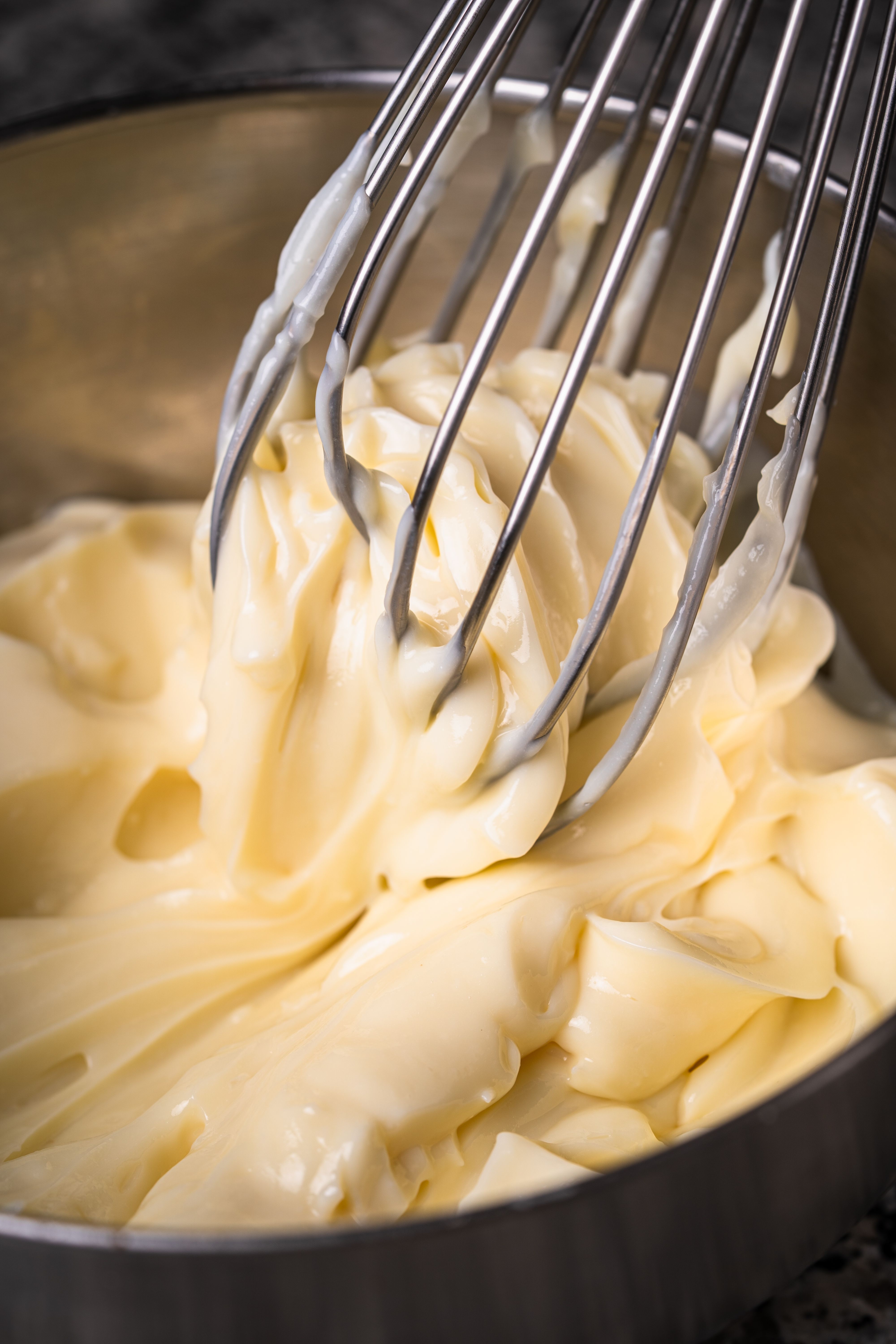 Homemade mayonnaise being whisked in a metal bowl