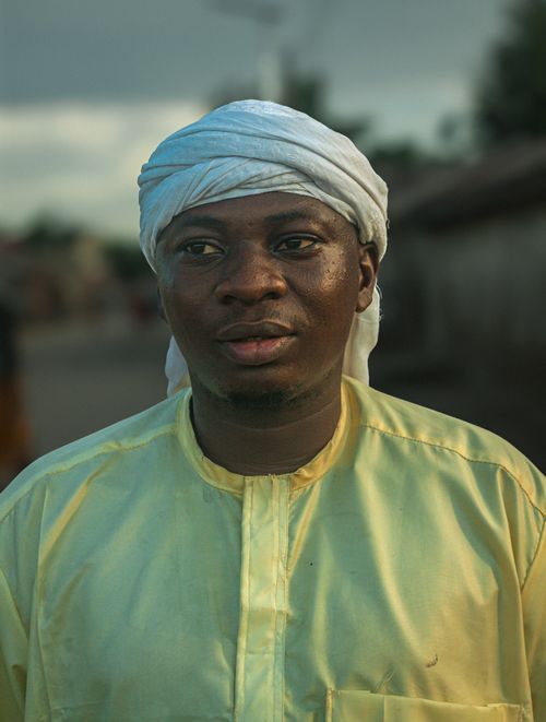 Free A close-up portrait of a man in traditional clothing with a serene expression, captured outdoors during the day. Stock Photo