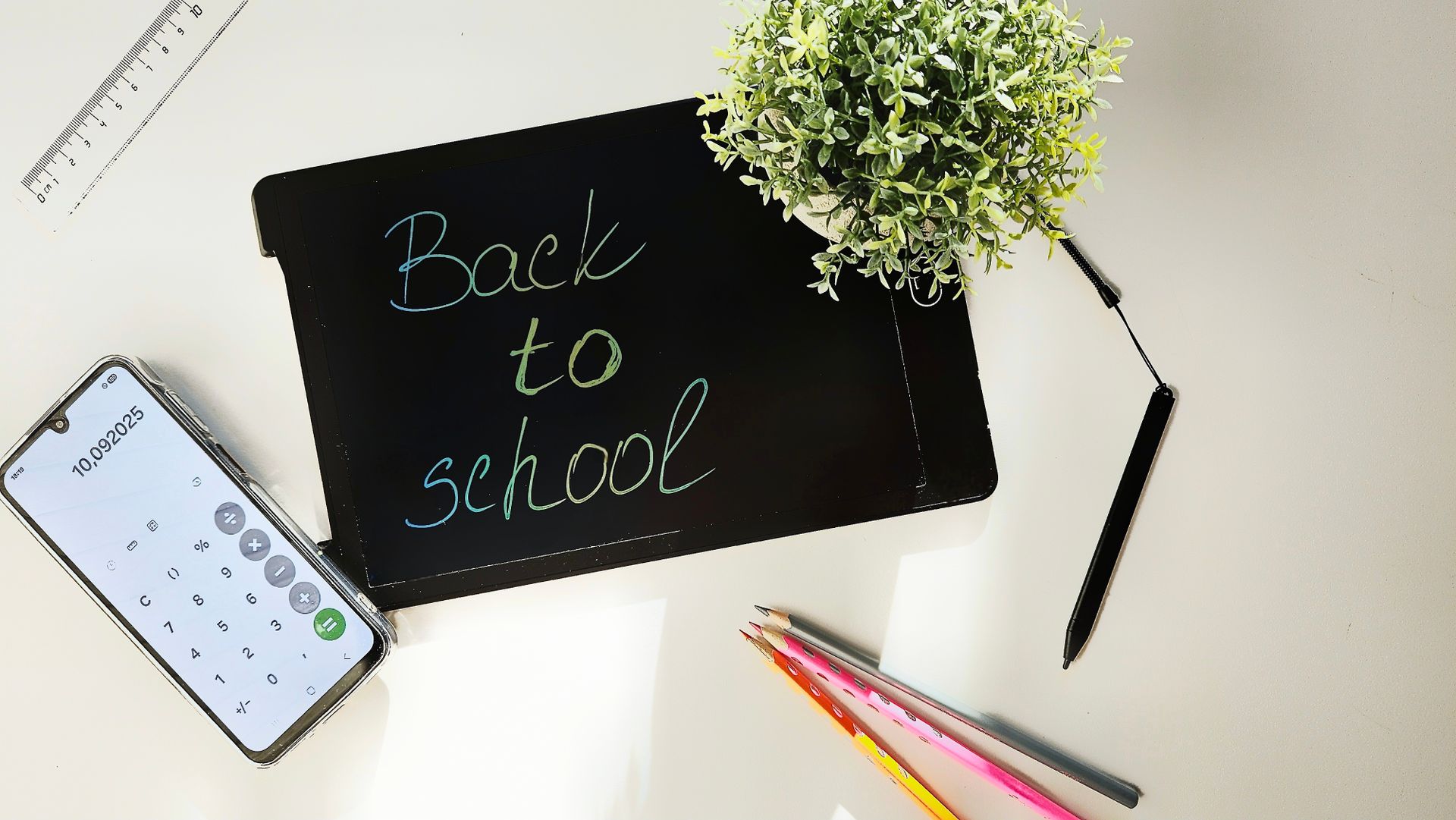 Creative back to school setup with stationery and tablet on desk.