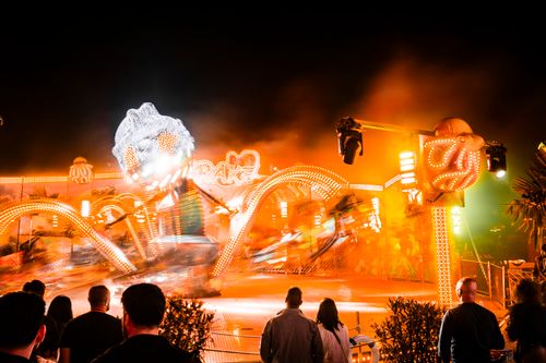Free Vibrant nighttime carnival scene with dynamic lights and blurred ride motion. Stock Photo