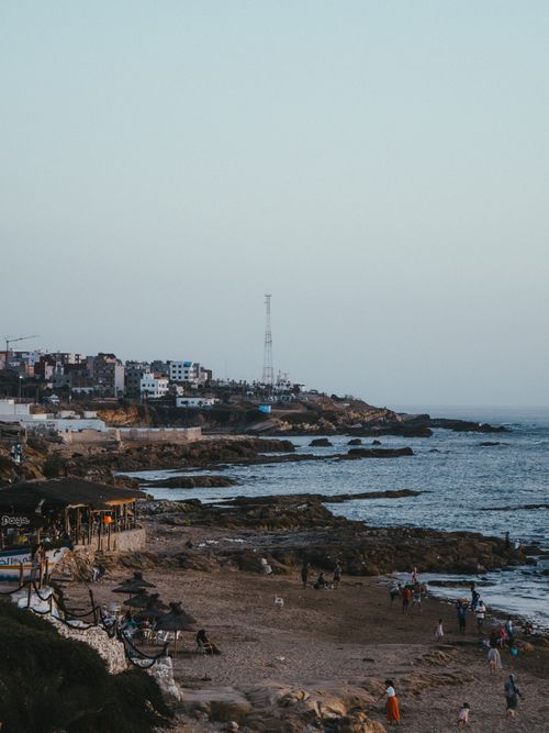Free Stunning coastal landscape of Asilah, Morocco, captured at sunset with rocky shores and tranquil sea. Stock Photo